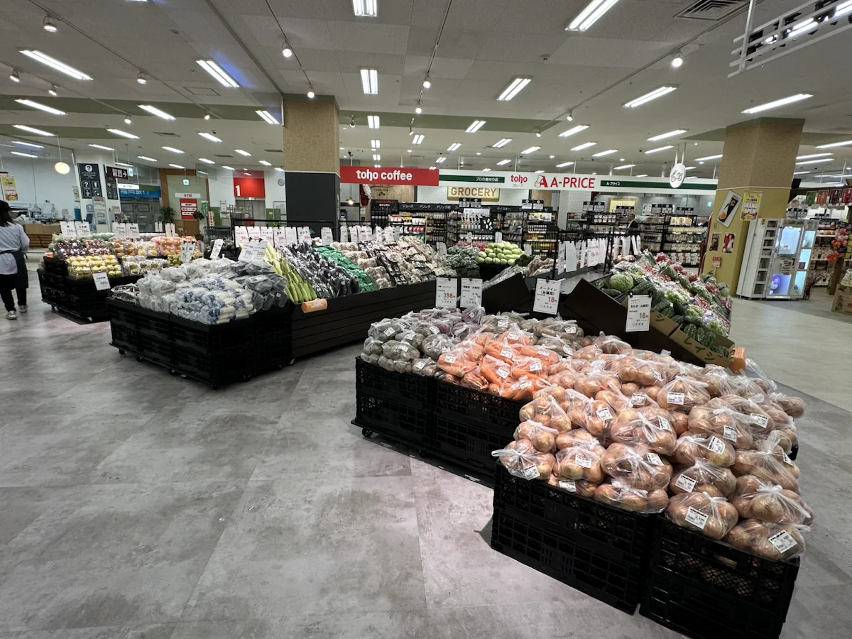 玉ねぎ、にんじん、じゃがいもなどが並ぶ良菜果の野菜売場